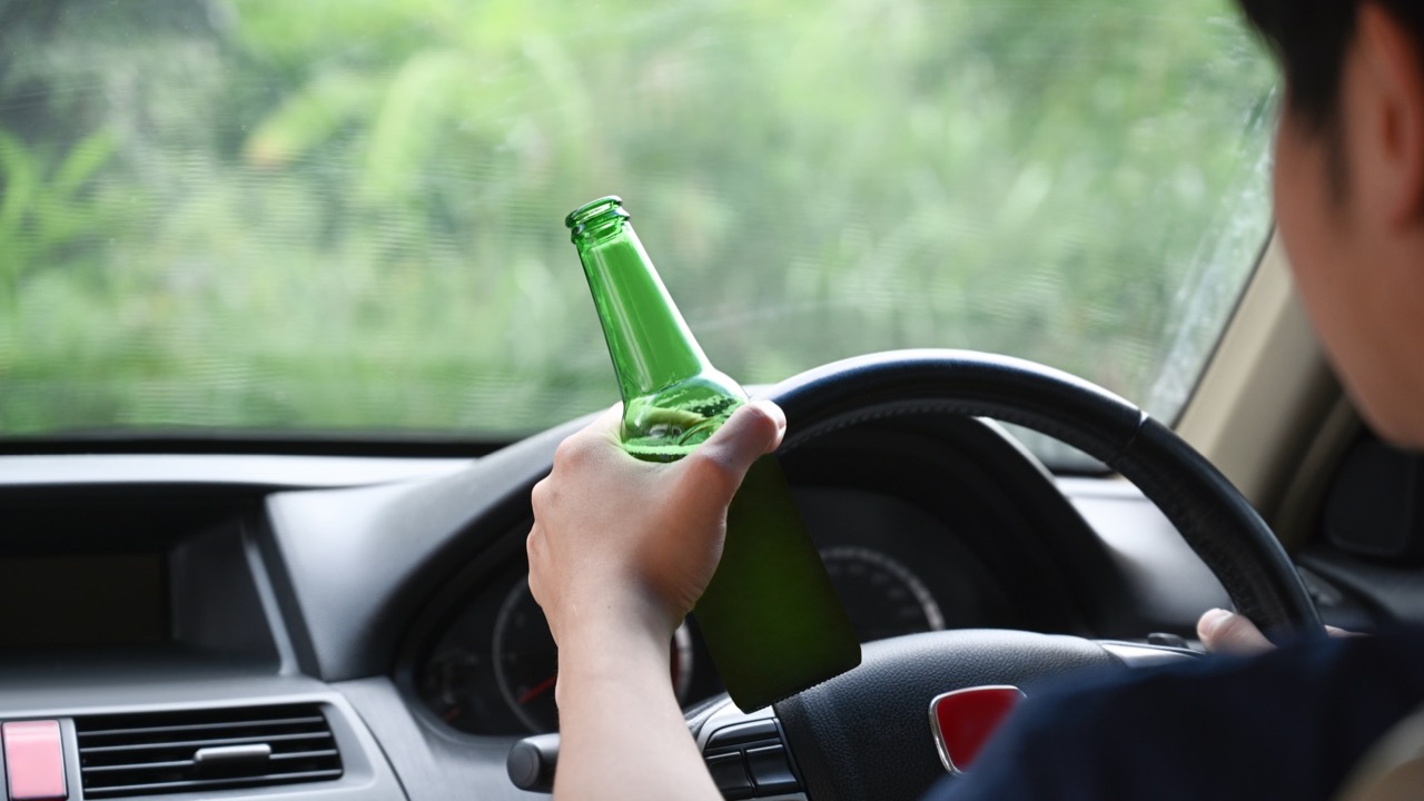 man-driving-a-car-while-holding-a-bottle-of-beer-2024-11-27-11-28-22-utc.jpg